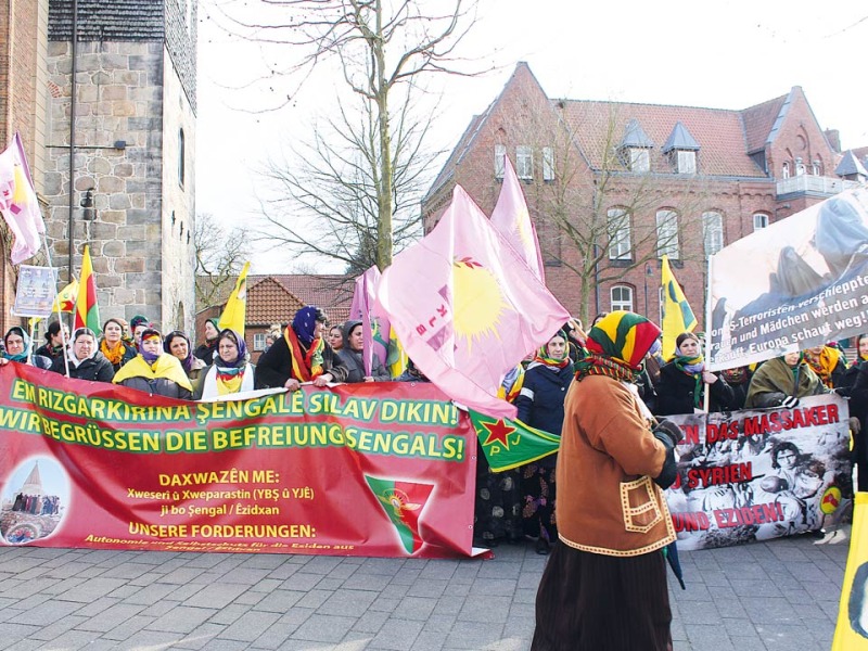 Mit lauten Rufen und eindringlichen Plakatsprüchen zieht die Gruppe ezidischer Frauen von der Walsroder Stadtkirche aus Richtung Bad Fallingbostel.