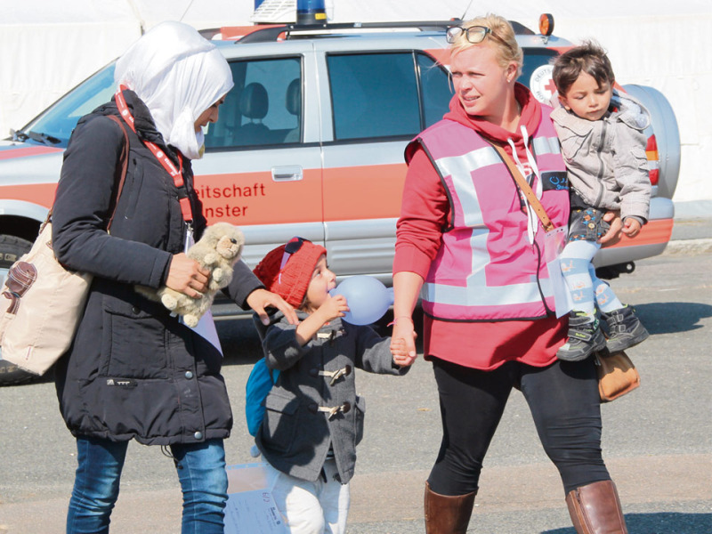 Der Anfang: Mitarbeiter zahlreicher Organisationen und freiwillige Helfer nehmen am 12. September 2015 die ersten Flüchtlinge im ehemaligen Nato-Truppenlager Oerbke in Empfang, das zur Notaufnahmeeinrichtung umfunktioniert wurde. Die Menschen sind erschöpft, traumatisiert, heimatlos.