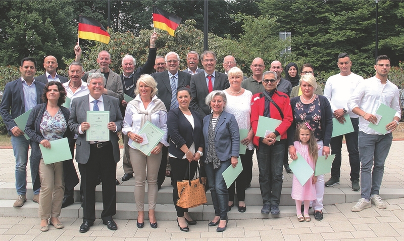 Gemeinsames Foto mit Landrat und Deutschlandfahne: Im Kreishaus fand eine Einbürgerungsfeier statt. rh