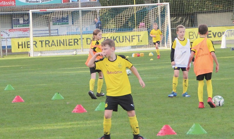 “Hier trainiert die Zukunft” verkündet das Plakat im Hintergrund: Die Borussia Dortmund-Fußballschule gastierte erstmals in Walsrode (li. Trainerin Vanessa Heim).