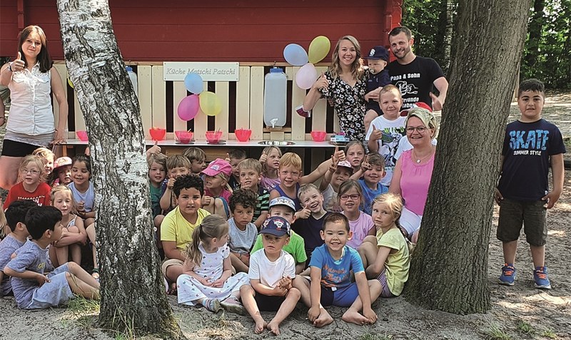 Zusammen mit Familie Birkheim, die die Spielküche “Matschi-Patschi” gebaut hat, wurde an der Kita Schulstraße in Hodenhagen die neue Außen-Spielmöglichkeit eingeweiht. Foto: Kita