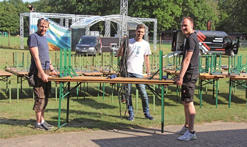 Christian Schuh, Sven Wittenberg und Felix Tiedemann (von links) fassen beim Aufbau für das Open Air am Dorfmarker Badeteich mit an. Foto: Manfred Eickholt