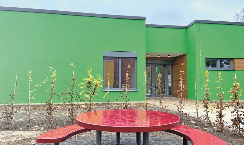 Grüne Fassade, rote Sitzgelegenheiten: Der Anbau an die Grundschule Vorbrück ist durchaus farbenfroh gestaltet.