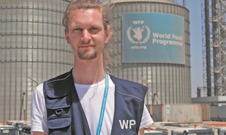 Paul Dettmer arbeitet seit vier Jahren f&Atilde;&frac14;r das Weltern&Atilde;&curren;hrungsprogramm: Immer wieder gibt er in den Einsatzgebieten Schulungen. Das Foto zeigt den 29-J&Atilde;&curren;hrigen vor den WFP-Silos der Humanit&Atilde;&curren;ren Logistik-Basis Djibouti in Ostafrika. Dort lagert WFP Nahrungsmittel, Fahrzeuge und andere Hilfsg&Atilde;&frac14;ter zwischen. Foto: WFP/Ana Heras