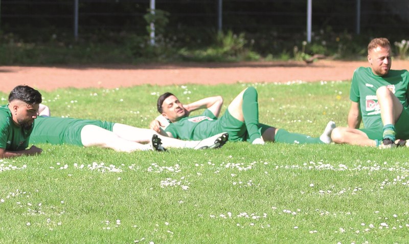 Entspanntes Sonnenbad statt echtes Mitfiebern beim Derby: Ciwan Walsrodes Reservespieler demonstrieren den launigen Saisonausklang. Foto: Künning