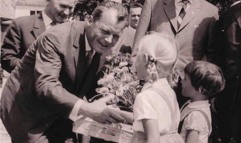 14. Juli 1961: Willy Brandt nimmt bei einem Besuch in Bomlitz Blumen und Heidelbeeren von Friedel Schlüters Kindern, Anette und Sabine, entgegen. Foto: privat
